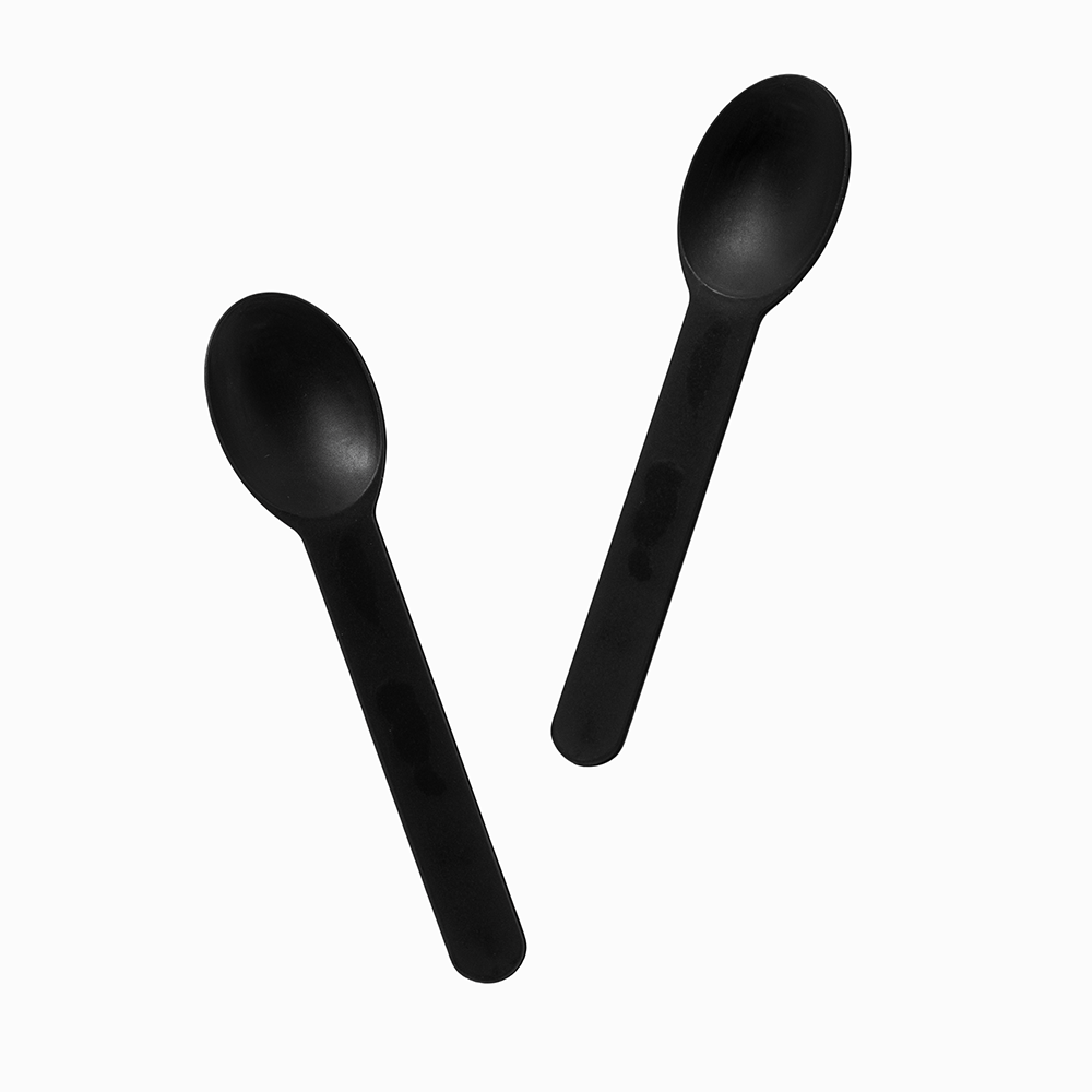 Black rigid plastic spoons arranged for premium heavy food service and catering.