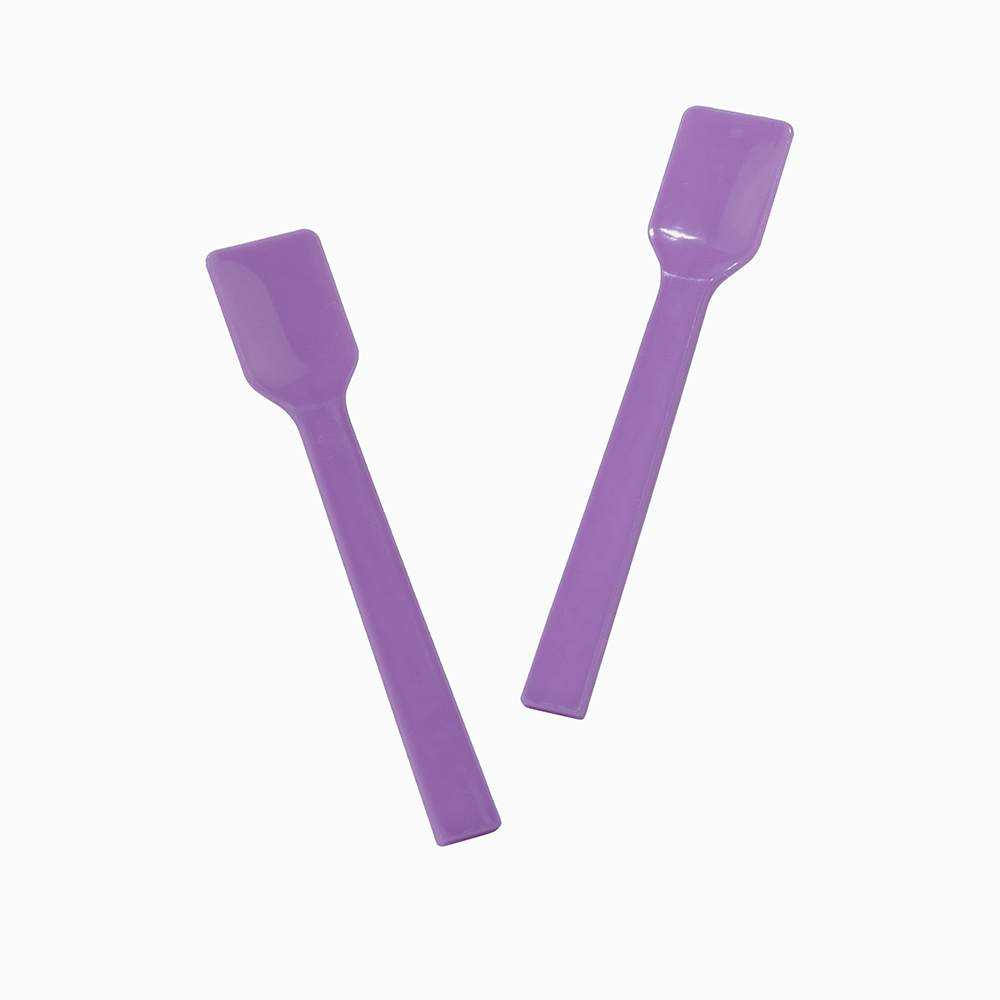 Two purple plastic gelato spoons in motion for serving thick frozen treats.