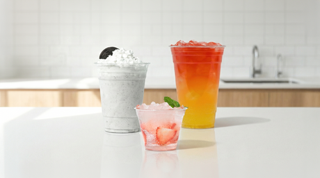 A wide selection of crystal-clear PET plastic cold cups with matching lids, showcasing wholesale beverage supplies for cafes and juice bars.