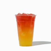 UNIQ 20 oz clear PET plastic cup featuring a vibrant yellow-to-red layered iced drink, highlighting crystal-clear visibility for wholesale specialty teas and energy drinks.