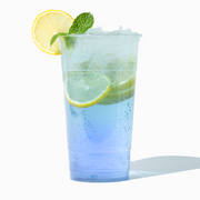 UNIQ 32 oz jumbo clear PET plastic cup featuring a vibrant iced beverage, highlighting maximum volume and crystal-clear clarity for wholesale juice bars and large drink service.