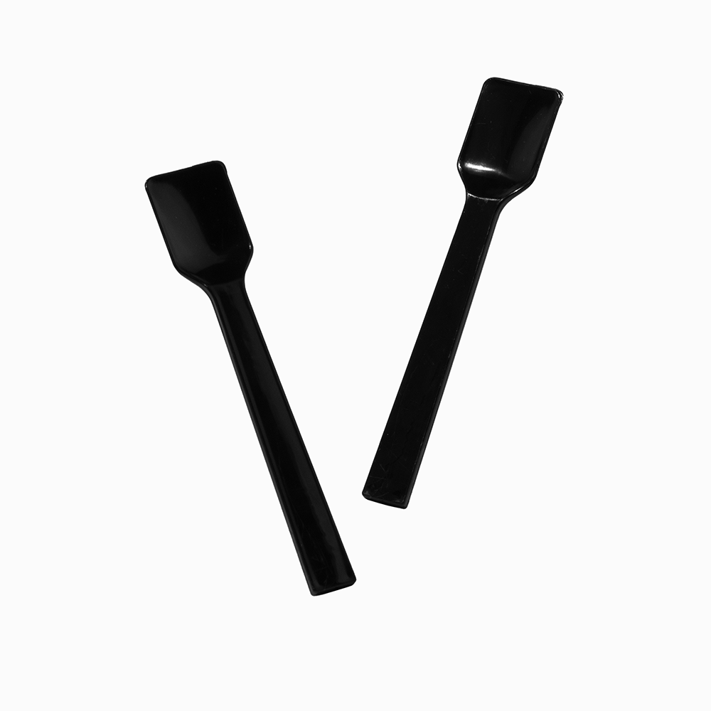 Two black plastic gelato spoons in motion for premium commercial service.