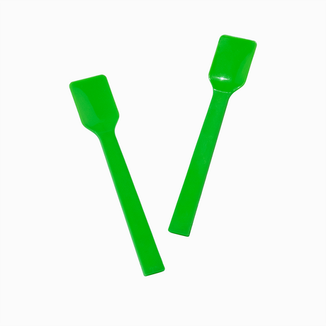 Two green plastic gelato spoons in motion for high-volume dessert scooping.