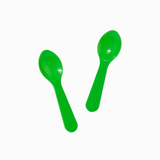 Green plastic tasting spoons in action for scooping ice cream and frozen yogurt samples.