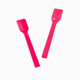 Two pink plastic gelato spades angled for scooping and portioning.