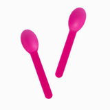 Pink durable plastic dessert spoons in action for scooping hard frozen yogurt.