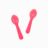 Pink mini plastic tasting spoons angled for presenting artisanal ice cream flavors.