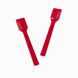 Two red plastic gelato spades in motion for serving high-volume desserts.