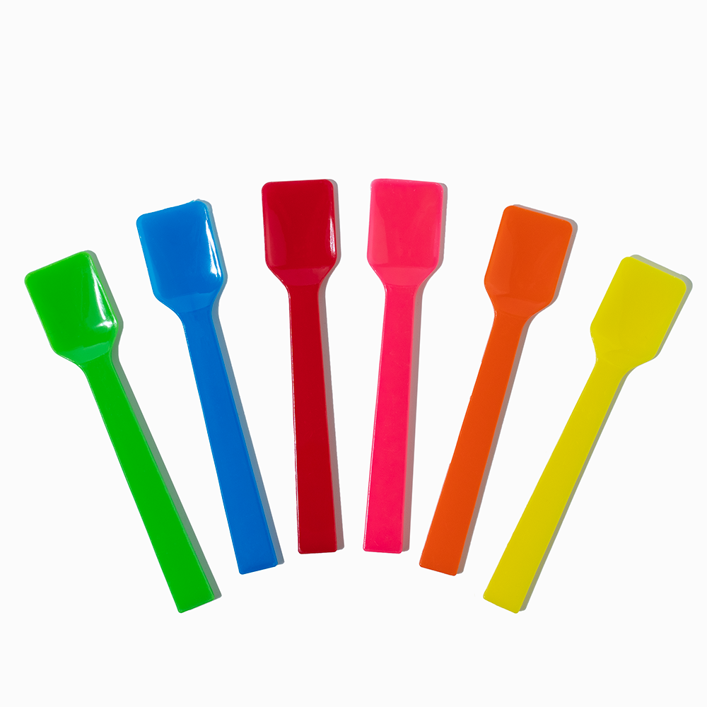 Assorted colors of flat-edge plastic gelato spoons fanned out for commercial dessert shops.