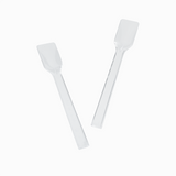 Two clear plastic gelato spoons angled for portioning authentic Italian ice.